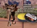 Ein abgenutzter Sattel wartet auf seine Pflege. Daneben steht eine Dose "Saddle Soap" für die gründliche Reinigung und Konservierung.