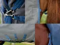 Nahaufnahme einer geschorenen braunen Pferdedecke mit stabilen Verschlüssen und dem "Rhino"-Logo.