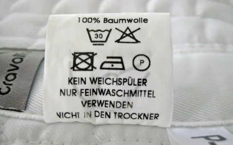 Pflegeetikett für Schabracken: 100% Baumwolle, bei 30°C waschen, kein Weichspüler, nur Feinwaschmittel verwenden, nicht in den Trockner.