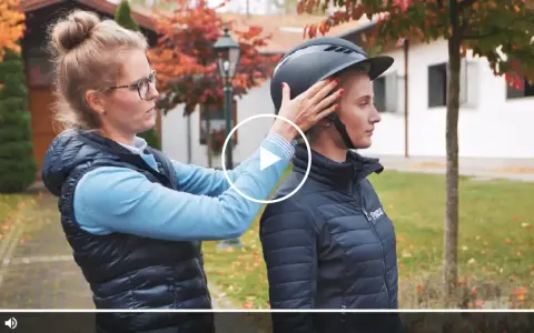 Frau passt Reiterin einen Helm an. Ein möglicher reithelm test stiftung warentest.