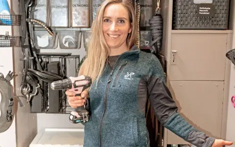 Frau richtet mit Akkuschrauber Pferdeausrüstung im Spind ein.