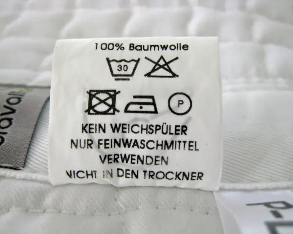 Pflegeetikett für Schabracken: 100% Baumwolle, bei 30°C waschen, kein Weichspüler, nur Feinwaschmittel verwenden, nicht in den Trockner.