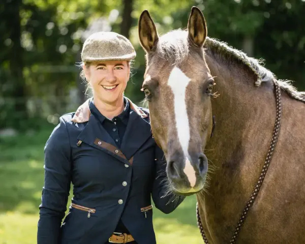 Lächelnde Reiterin mit Pferd, bereit für Working Equitation Einsteiger.