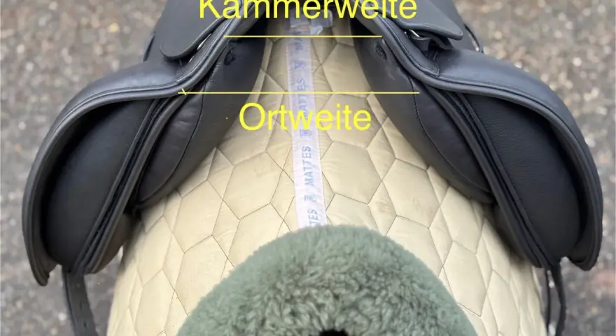 Schwarzer Sattel mit gelben Markierungen für Kammerweite und Ortweite. Ein Maßband liegt darunter.