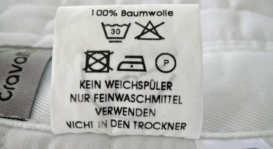 Pflegeetikett für Schabracken: 100% Baumwolle, bei 30°C waschen, kein Weichspüler, nur Feinwaschmittel verwenden, nicht in den Trockner.