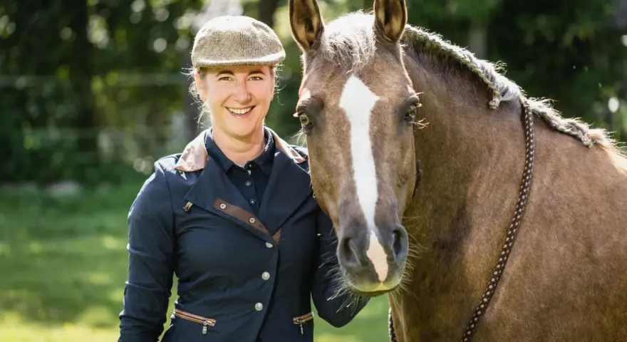 Lächelnde Reiterin mit Pferd, bereit für Working Equitation Einsteiger.
