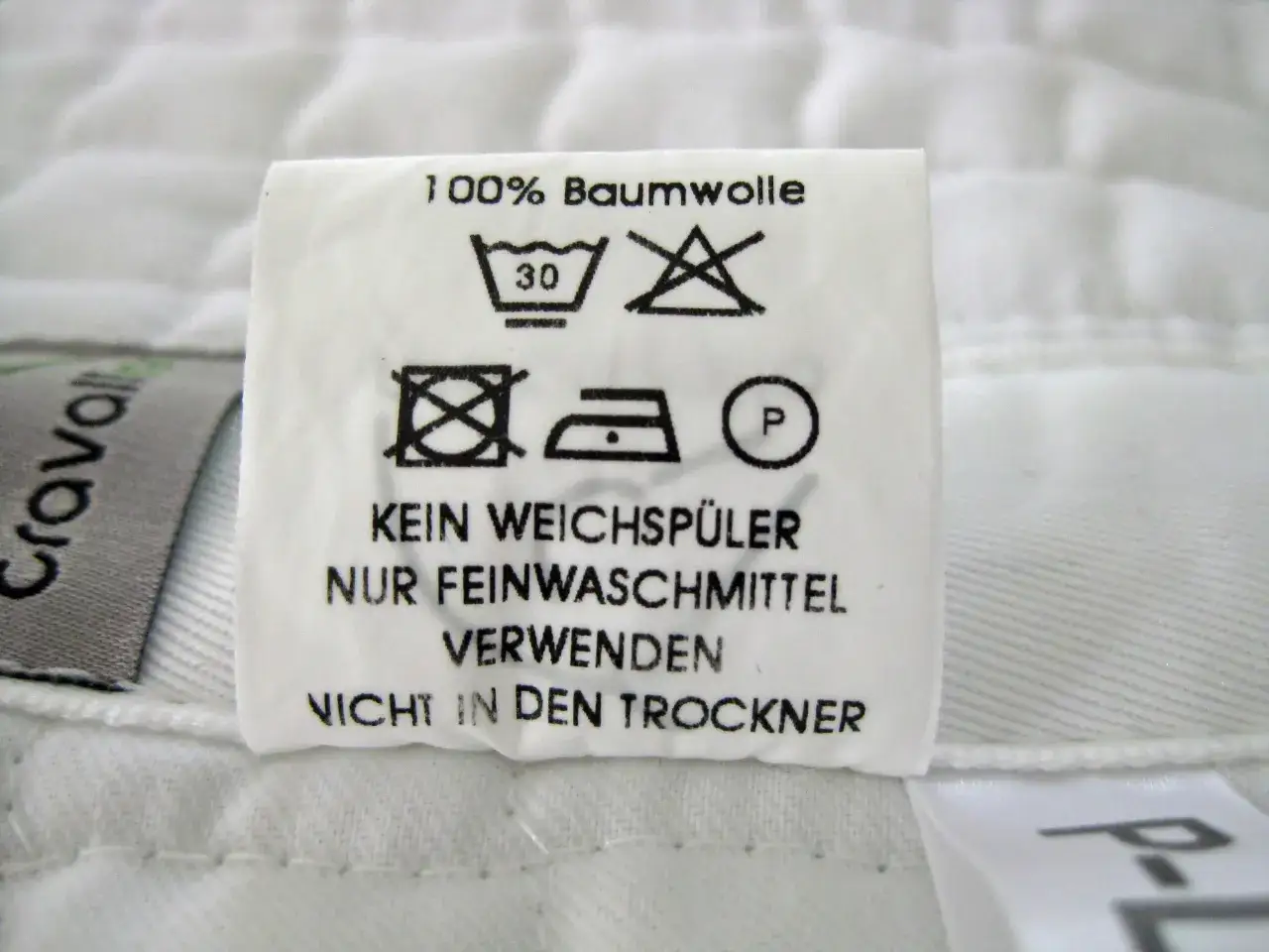 Pflegeetikett für Schabracken: 100% Baumwolle, bei 30°C waschen, kein Weichspüler, nur Feinwaschmittel verwenden, nicht in den Trockner.